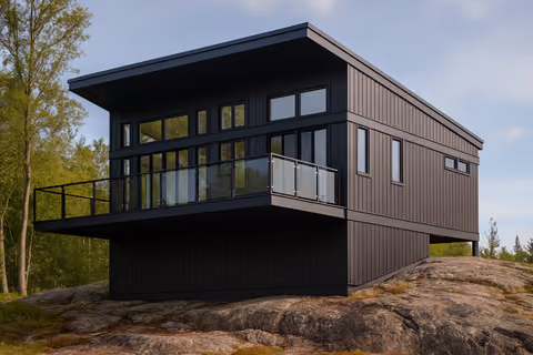 Modern black cottage on exposed rock with a glass balcony